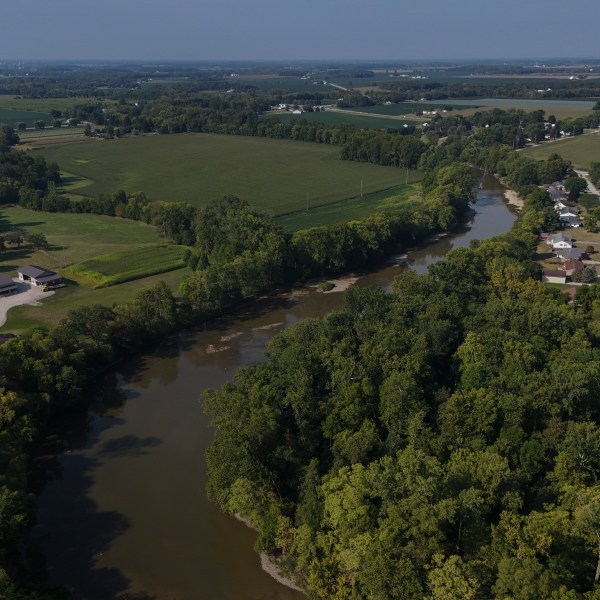 FILE - Water flows down the Sandusky River between farms, Aug. 26, 2024, in Fremont, Ohio. (AP Photo/Joshua A. Bickel, File)