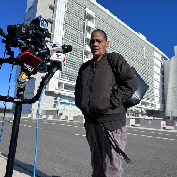 Elizabeth Alvarado, the mother of Nisa Mickens, a 15-year-old who was killed by MS-13 gang members in 2016, speaks outside the federal court, behind, in Central Islip, New York, where Jairo Saenz, a high-ranking member of a local MS-13 clique, pleaded guilty to racketeering and other federal charges on Tuesday, Jan. 14, 2025. (AP Photo/Philip Marcelo)