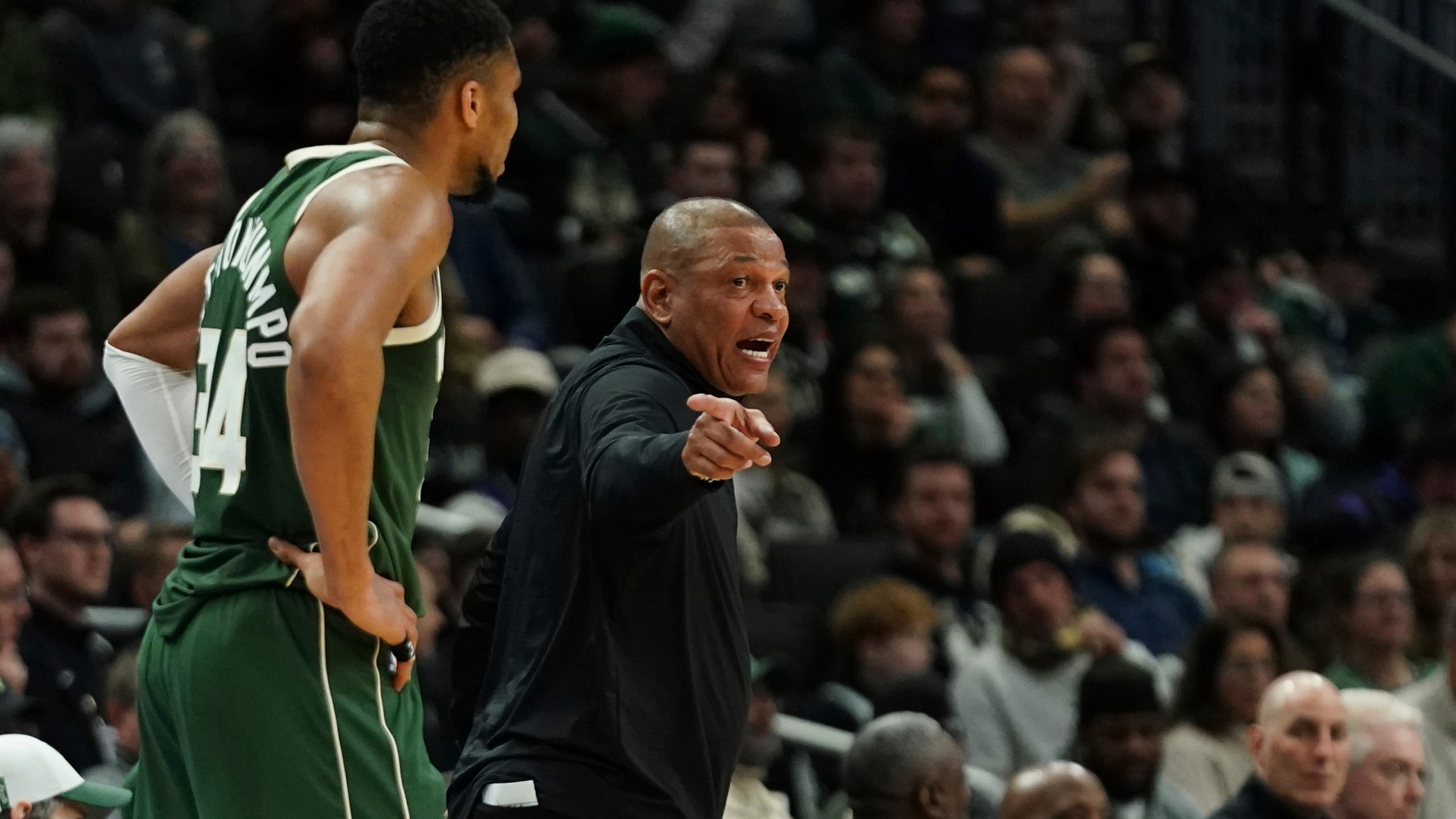 Milwaukee Bucks head coach Doc Rivers, right, gestures as he talks with Giannis Antetokounmpo during the first half of an NBA basketball game against the Sacramento Kings, Tuesday, Jan. 14, 2025, in Milwaukee. (AP Photo/Aaron Gash)