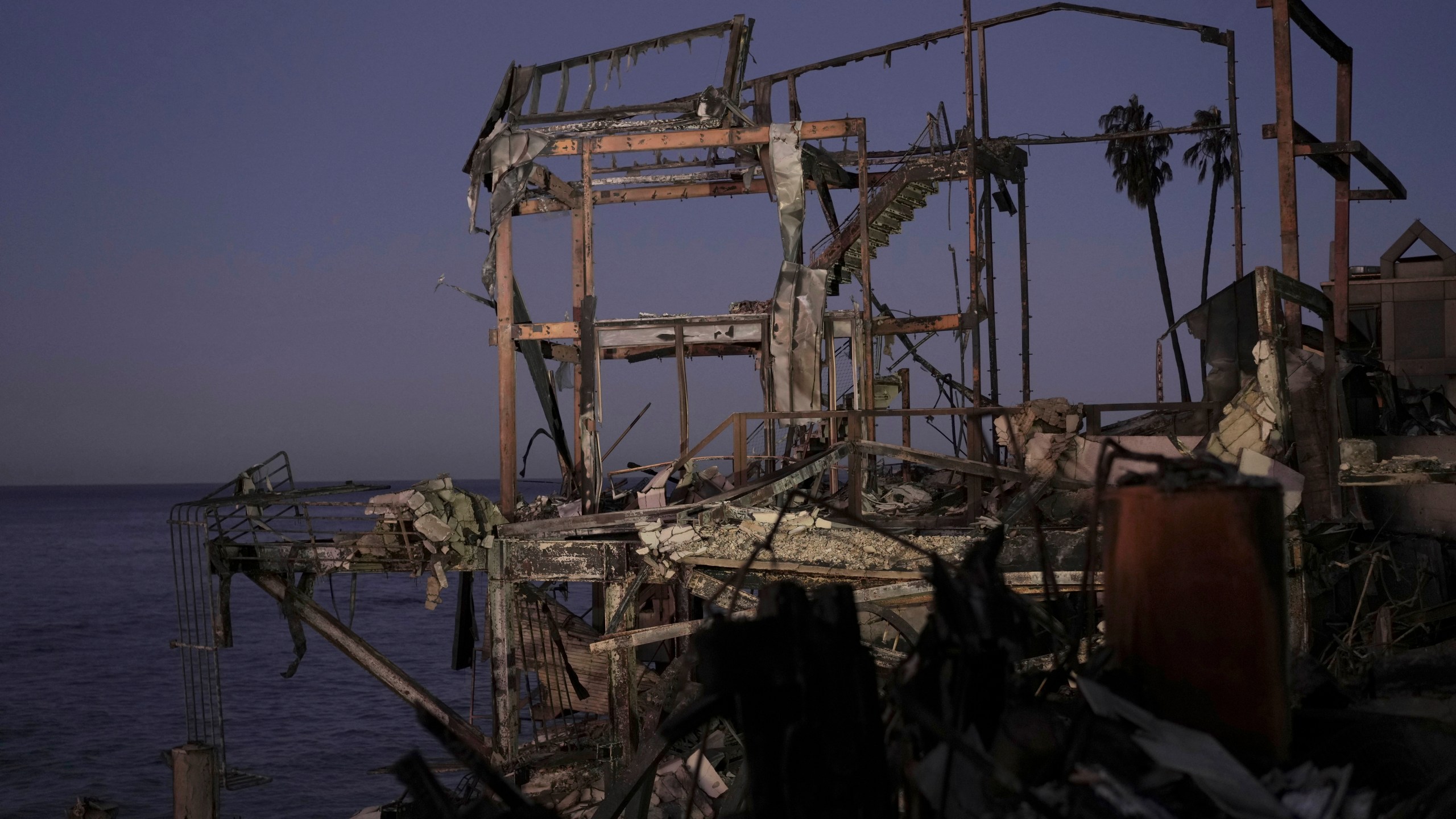 The sun rises behind a burned out home in Malibu, Calif., Tuesday, Jan. 14, 2025. (AP Photo/Carolyn Kaster)