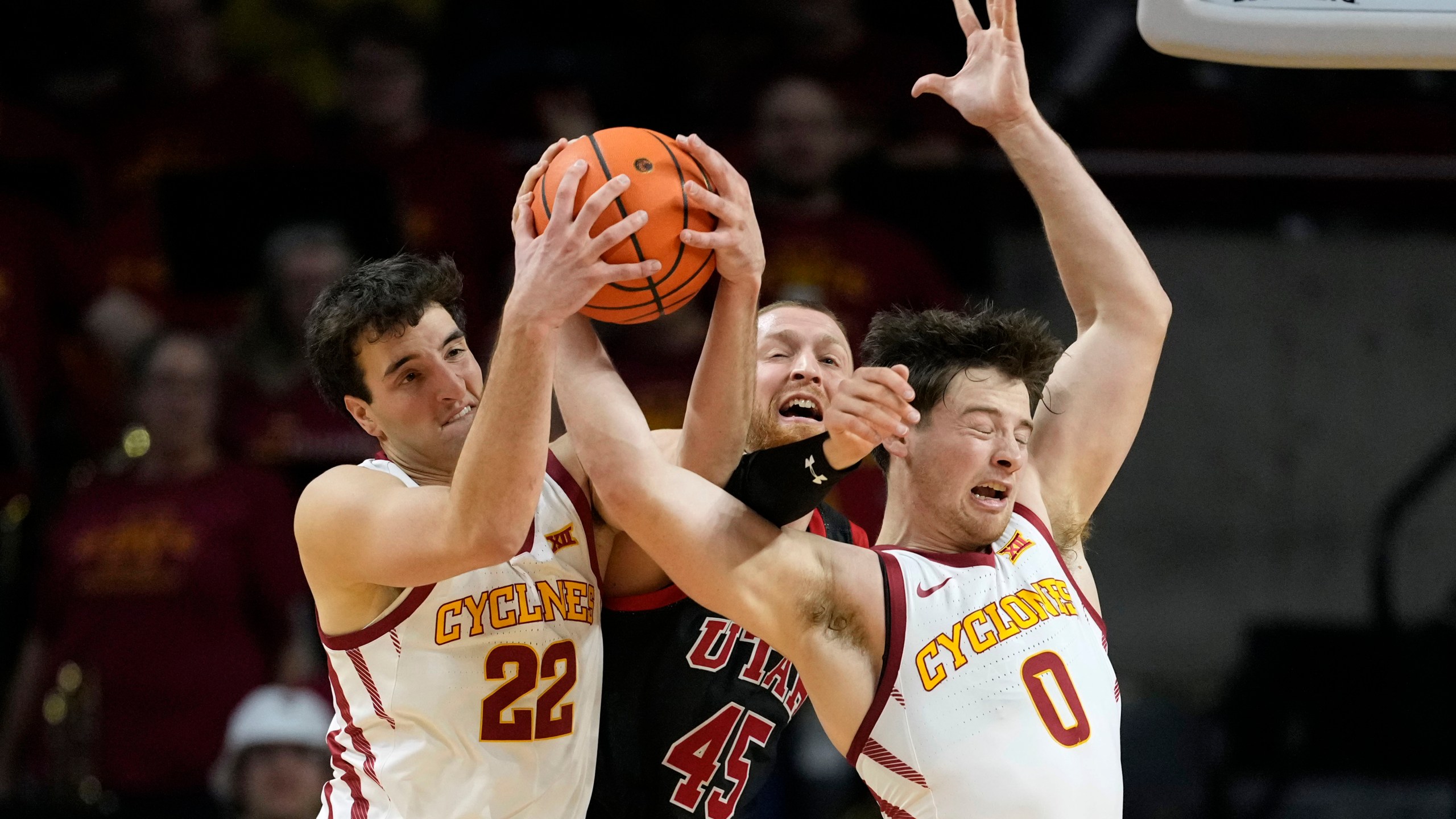 Iowa State forward Milan Momcilovic (22) and guard Nate Heise (0) fight for a rebound with Utah guard Mason Madsen (45) during the second half of an NCAA college basketball game Tuesday, Jan. 7, 2025, in Ames, Iowa. (AP Photo/Charlie Neibergall)