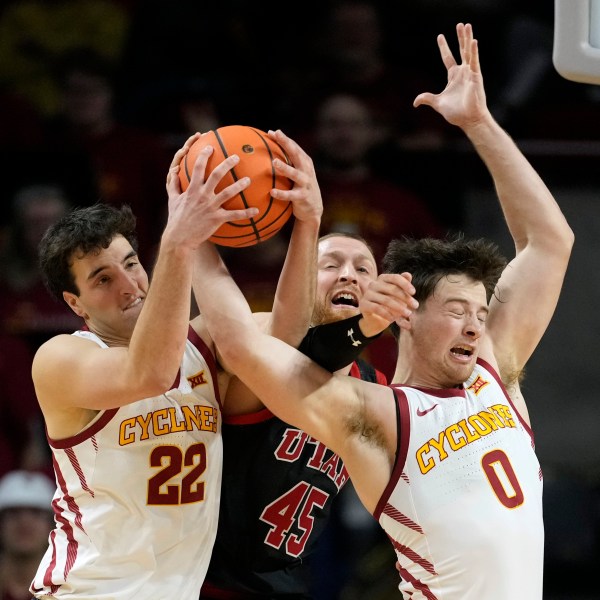 Iowa State forward Milan Momcilovic (22) and guard Nate Heise (0) fight for a rebound with Utah guard Mason Madsen (45) during the second half of an NCAA college basketball game Tuesday, Jan. 7, 2025, in Ames, Iowa. (AP Photo/Charlie Neibergall)