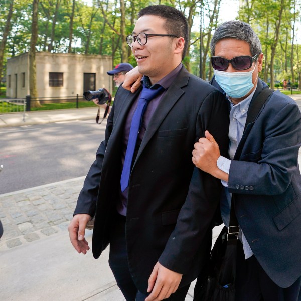 FILE - Zhu Yong, right, tries to shield himself from photographers as he leaves federal court, May 31, 2023, in the Brooklyn borough of New York. (AP Photo/Mary Altaffer, File)