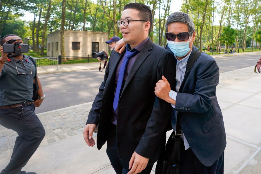 FILE - Zhu Yong, right, tries to shield himself from photographers as he leaves federal court, May 31, 2023, in the Brooklyn borough of New York. (AP Photo/Mary Altaffer, File)