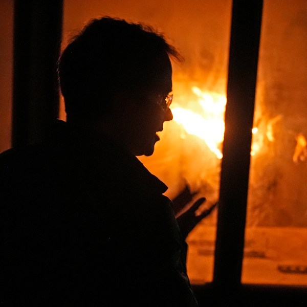 James Urban, assistant professor in the department of Fire Protection Engineering at Worcester Polytechnic Institute, watches a fire burn in a wind tunnel, Wednesday, Jan. 15, 2025, in Worcester, Mass. (AP Photo/Robert F. Bukaty)