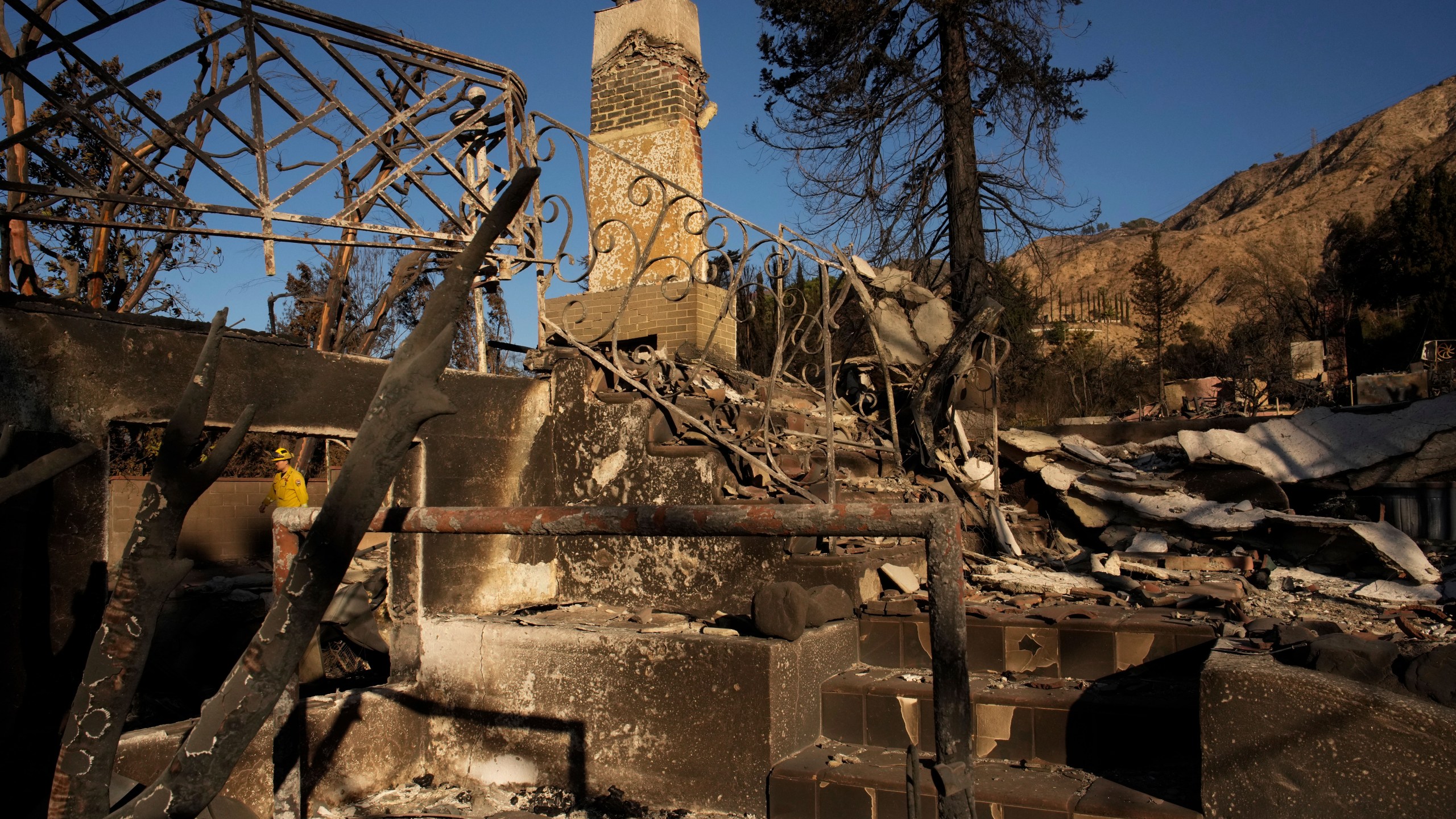 A firefighter inspects homes destroyed by the Eaton Fire in in Altadena, Calif., is seen Wednesday, Jan 15, 2025. (AP Photo/John Locher)