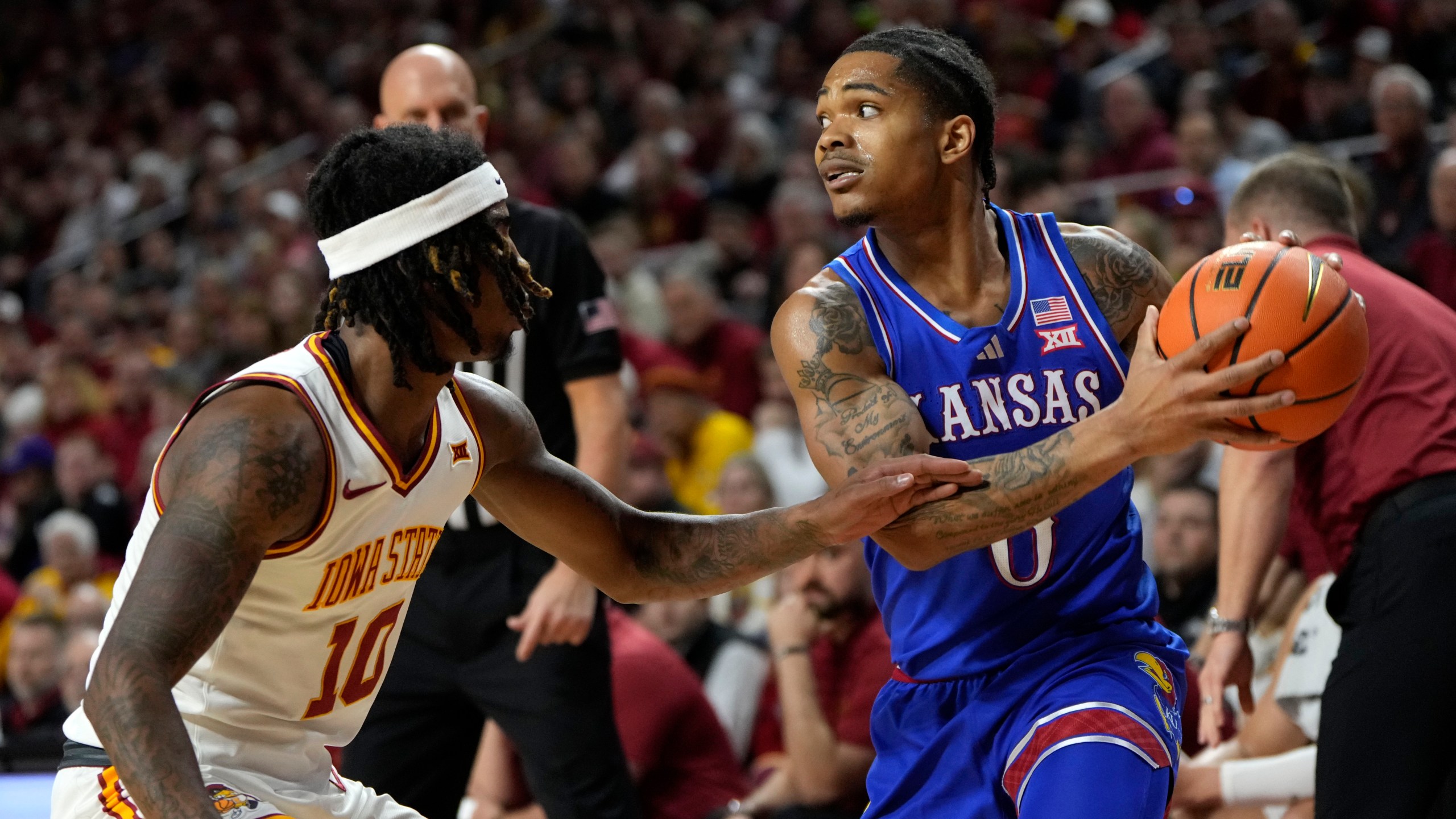 Kansas guard Shakeel Moore looks to pass over Iowa State guard Keshon Gilbert (10) during the first half of an NCAA college basketball game Wednesday, Jan. 15, 2025, in Ames, Iowa. (AP Photo/Charlie Neibergall)