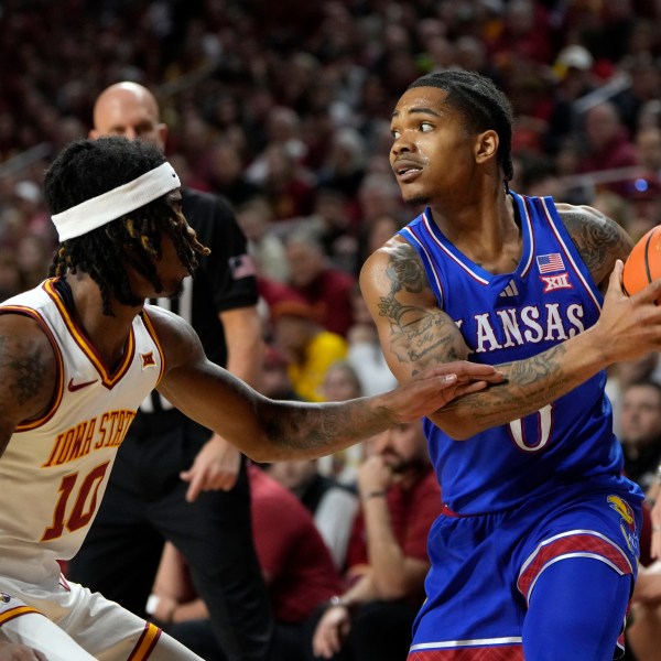 Kansas guard Shakeel Moore looks to pass over Iowa State guard Keshon Gilbert (10) during the first half of an NCAA college basketball game Wednesday, Jan. 15, 2025, in Ames, Iowa. (AP Photo/Charlie Neibergall)