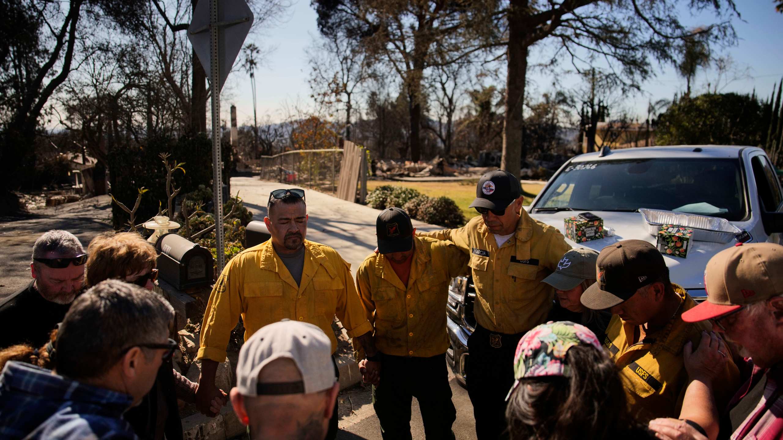 Firefighters with the U.S. Forest Service gather to pray with others, Wednesday, Jan. 15, 2025, in Altadena, Calif. (AP Photo/John Locher)