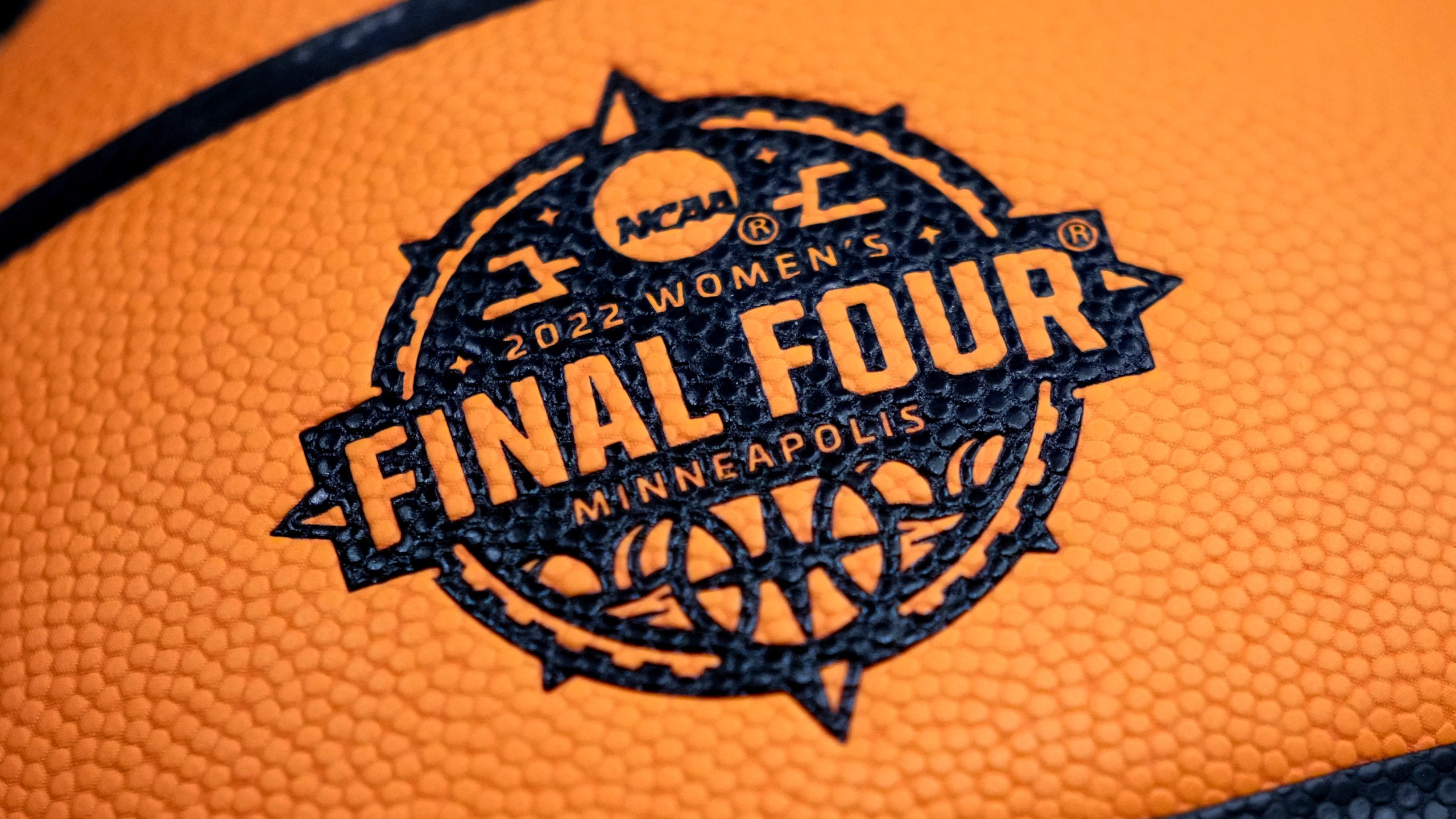 FILE - A logo is seen on a basketball during a practice session for a college basketball game in the final round of the Women's Final Four NCAA tournament Saturday, April 2, 2022, in Minneapolis. (AP Photo/Charlie Neibergall, File)