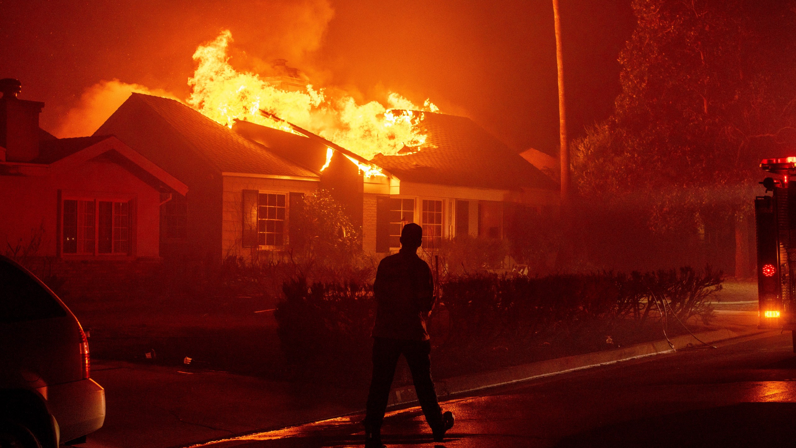 FILE - A firefighter walks toward a burning structure as the Eaton Fire advances Tuesday, Jan. 7, 2025 in Altadena, Calif. (AP Photo/Ethan Swope, File)