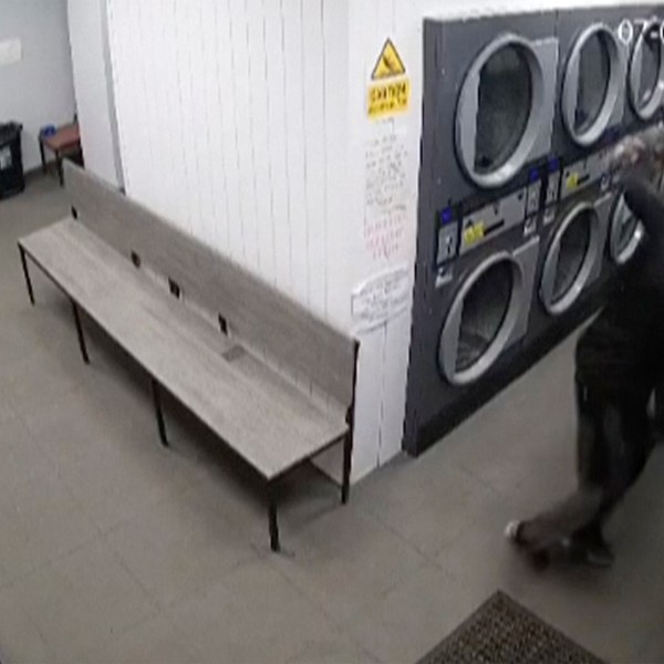 In this grab taken from CCTV from a Launderette in Maltby, a man fights off a mugger with a pair of trousers, in Maltby, England. (CCTV from a Launderette in Maltby via AP)