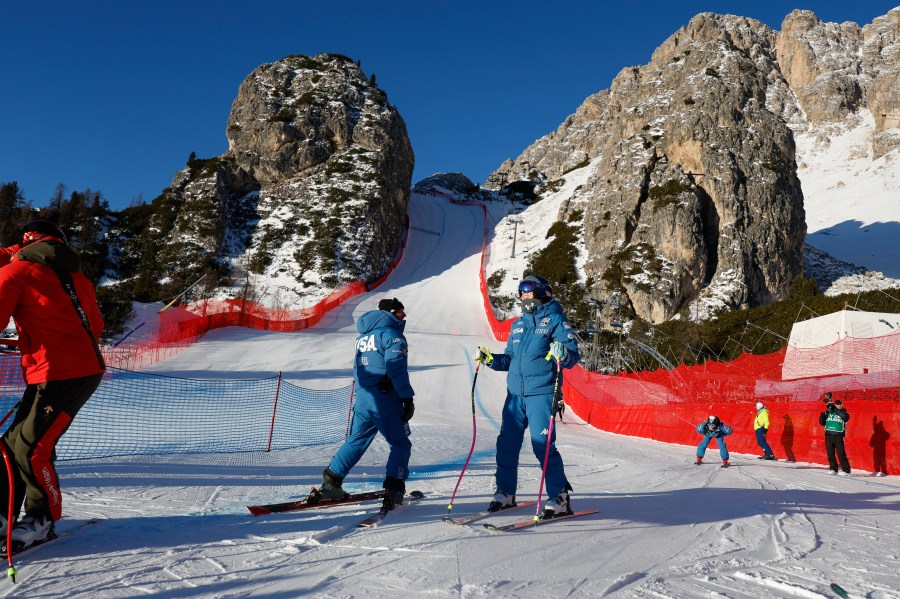 United States' Lindsey Vonn, center right, inspects the course ahead of an alpine ski, women's World Cup downhill training, in Cortina d'Ampezzo, Italy, Thursday, Jan. 16, 2025. (AP Photo/Alessandro Trovati)