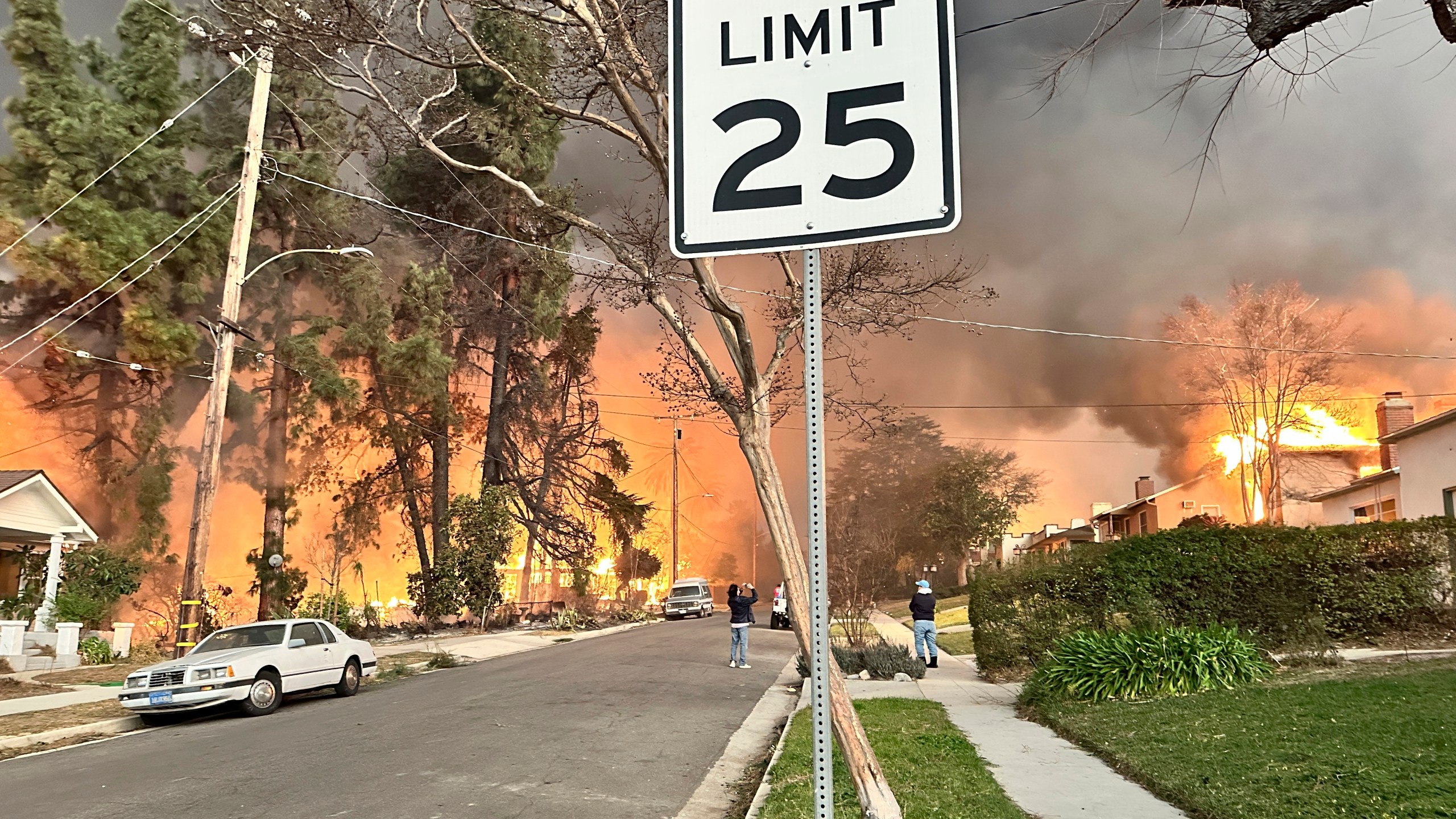 The Eaton Fire burns homes as Ryan Pearson, a Los Angeles-based entertainment video editor for The Associated Press, drives through his neighborhood in Altadena, Calif., Wednesday, Jan. 8, 2025. (AP Photo/Ryan Pearson)