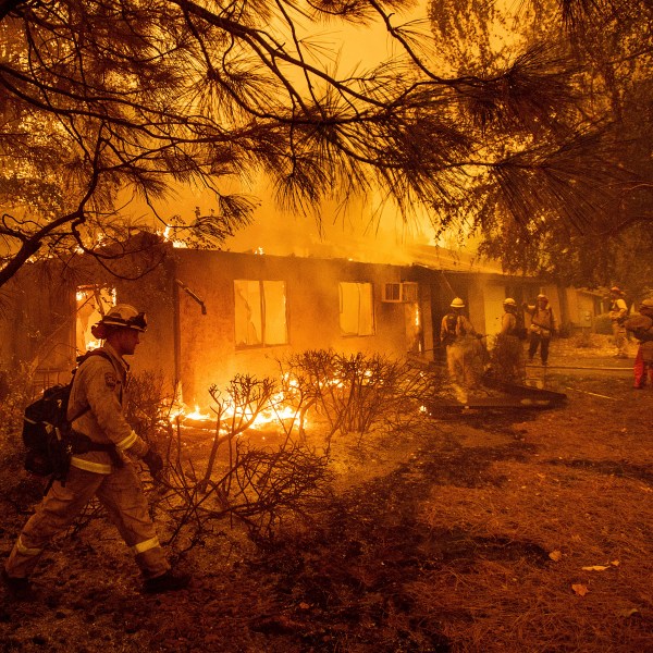 FILE - Firefighters work to keep flames from spreading through the Shadowbrook apartment complex as a wildfire burns through Paradise, Calif., on Nov. 9, 2018. (AP Photo/Noah Berger, File)