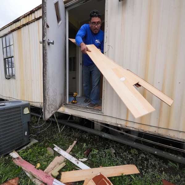 Mario Mendoza works on repairing a mobile home in Belle Chasse, La., Wednesday, Jan. 15, 2025, that was damaged from Hurricane Ida in 2021. (AP Photo/Gerald Herbert)