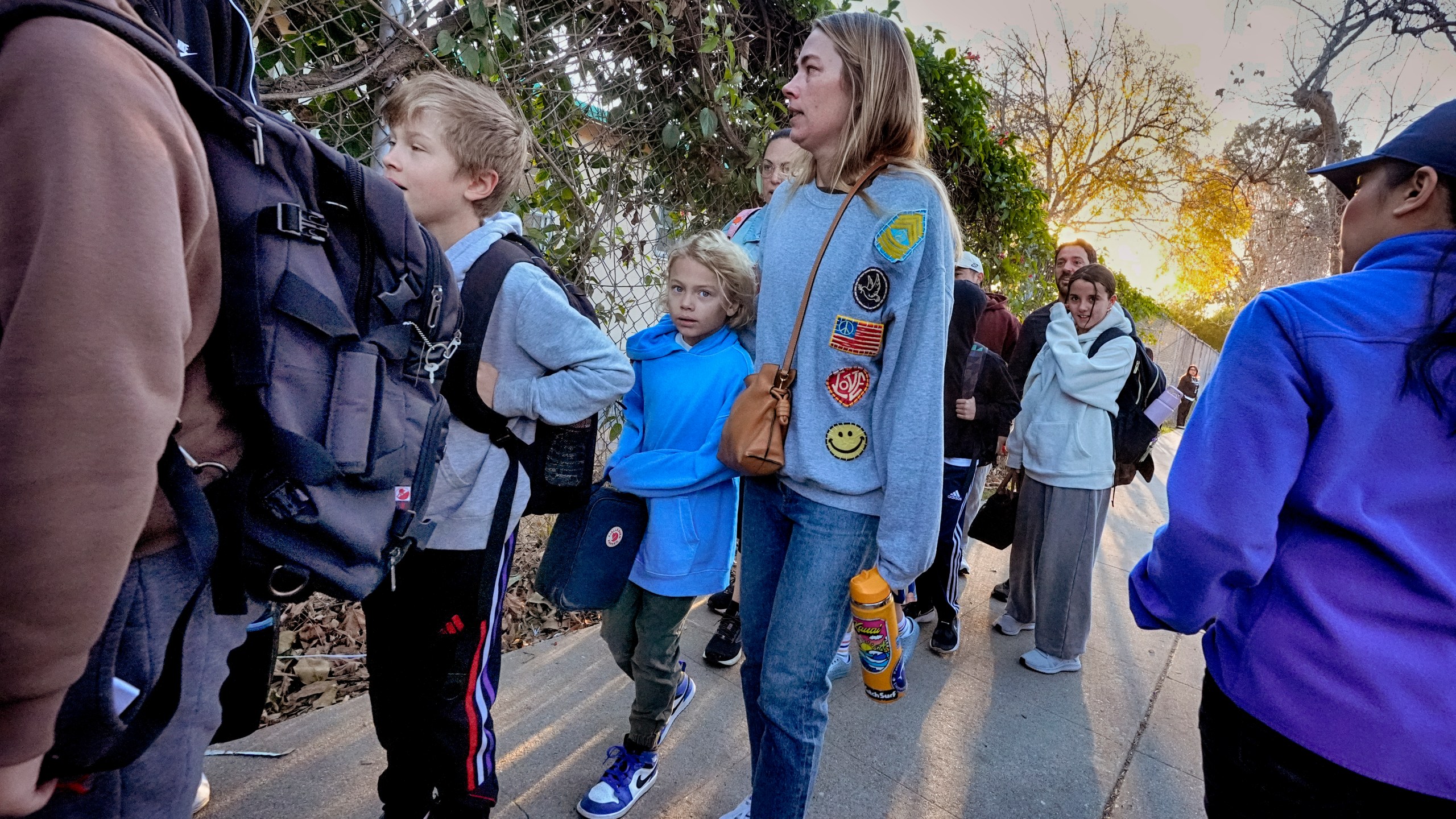 Palisades Charter Elementary School students and their parents arrive at their new school, the Brentwood Elementary Science Magnet school in the Brentwood section of Los Angeles on Wednesday, Jan. 15, 2025. (AP Photo/Richard Vogel)