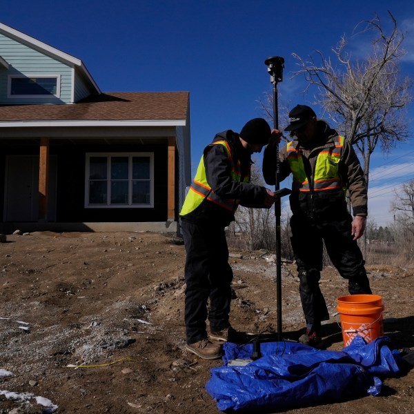 Technicians install a new water meter with a remote shutoff valve Thursday, Feb. 13, 2025, in Louisville, Colo. (AP Photo/Brittany Peterson)