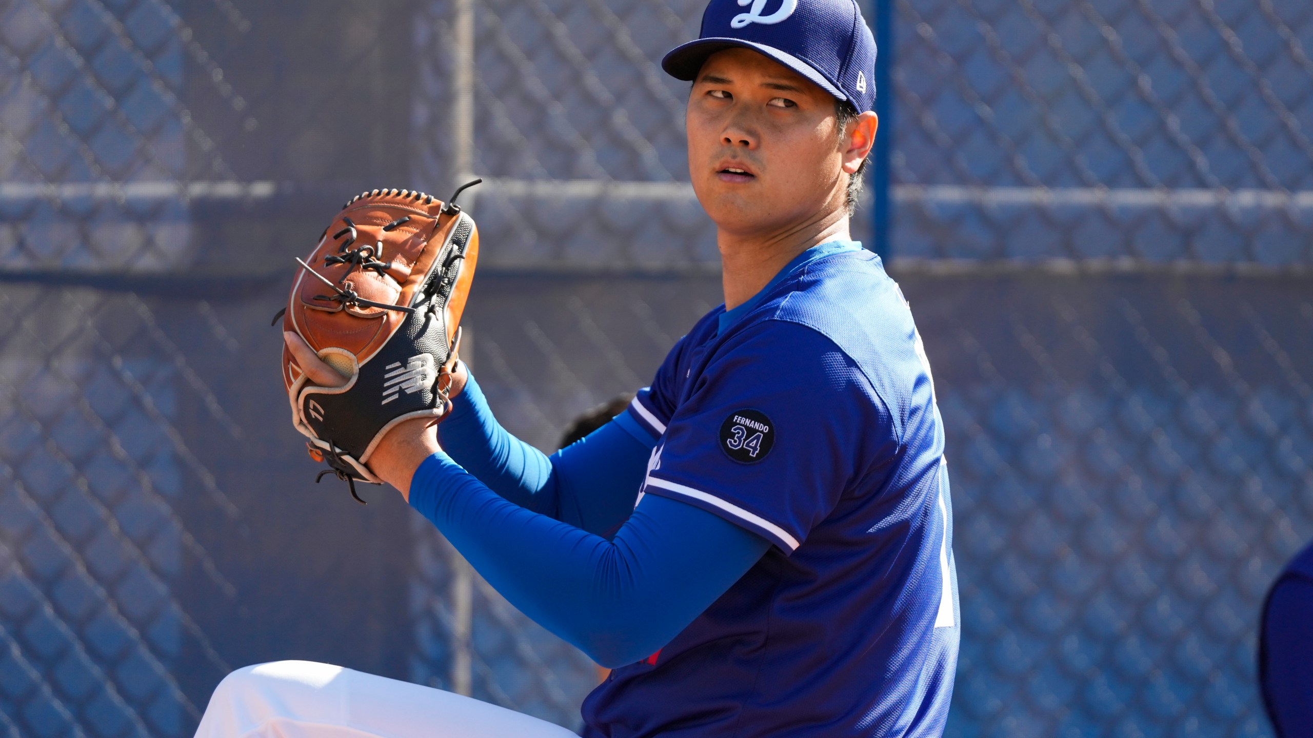 Los Angeles Dodgers two-way player Shohei Ohtani (17) throws in the bullpen during spring training baseball practice, Tuesday, Feb. 18, 2025, in Phoenix. (AP Photo/Ashley Landis)