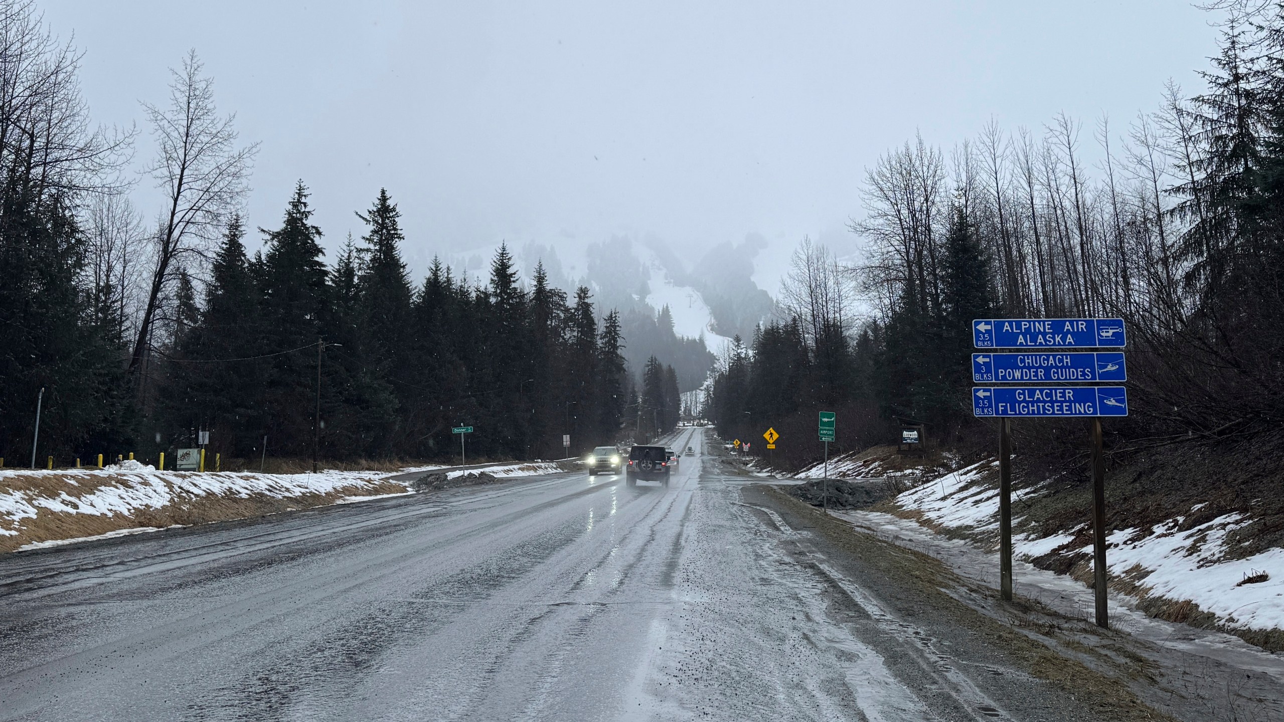 A sign on Alyeska Highway points to winter tourism businesses in Girdwood, Alaska, on Wednesday, March 1, 2025. (AP Photo/Mark Thiessen)