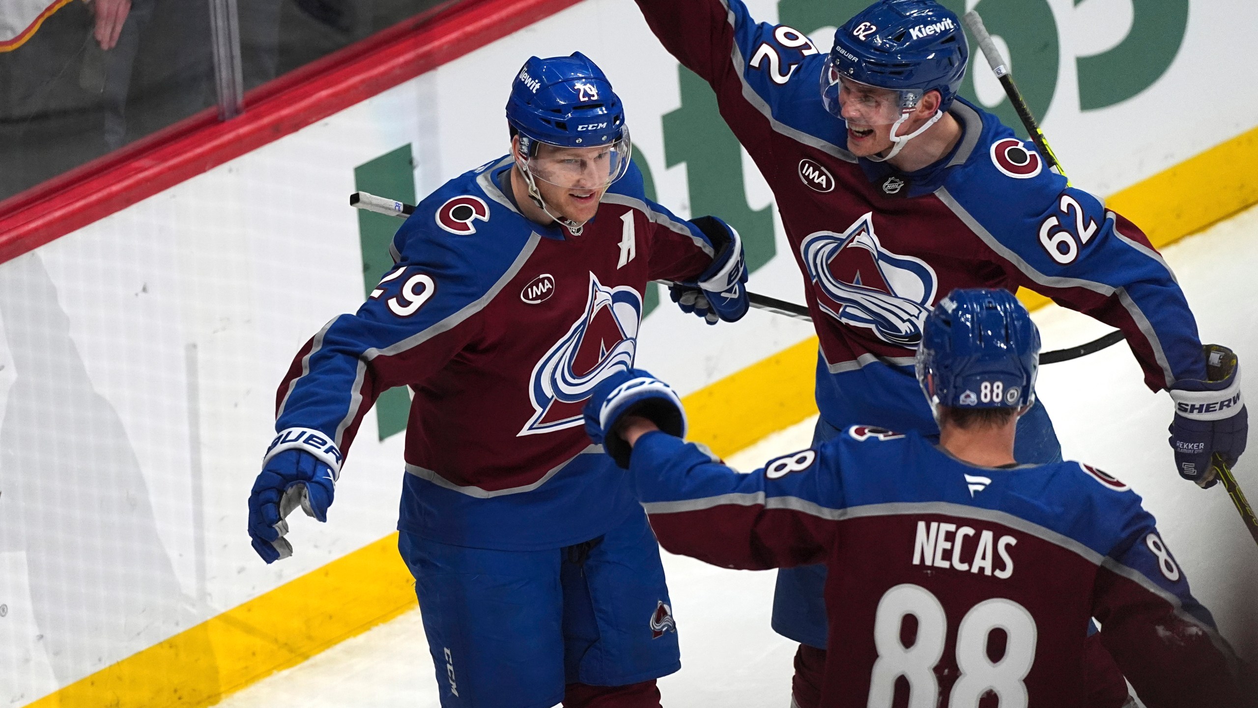 Colorado Avalanche center Nathan MacKinnon, left, is congratulated after scoring a goal by left wing Artturi Lehkonen, back right, and center Martin Necas in the third period of an NHL hockey game against the New Jersey Devils Wednesday, Feb. 26, 2025, in Denver. (AP Photo/David Zalubowski)