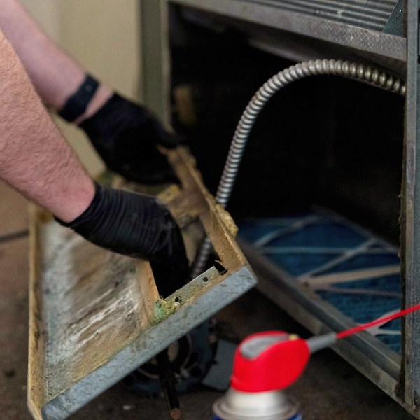 James Richardson takes apart a heating and cooling unit in an apartment being updated at Smith Tower Apartments, on Monday, March 10, 2025, in Vancouver, Wash. (AP Photo/Jenny Kane)