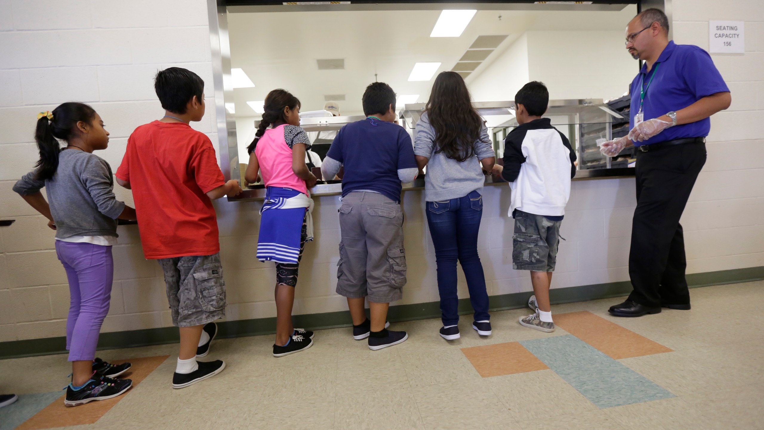 FILE - In this Sept. 10, 2014, file photo, detained immigrant children line up in the cafeteria at the Karnes County Residential Center, a detention center for immigrant families, in Karnes City, Texas. (AP Photo/Eric Gay, File)