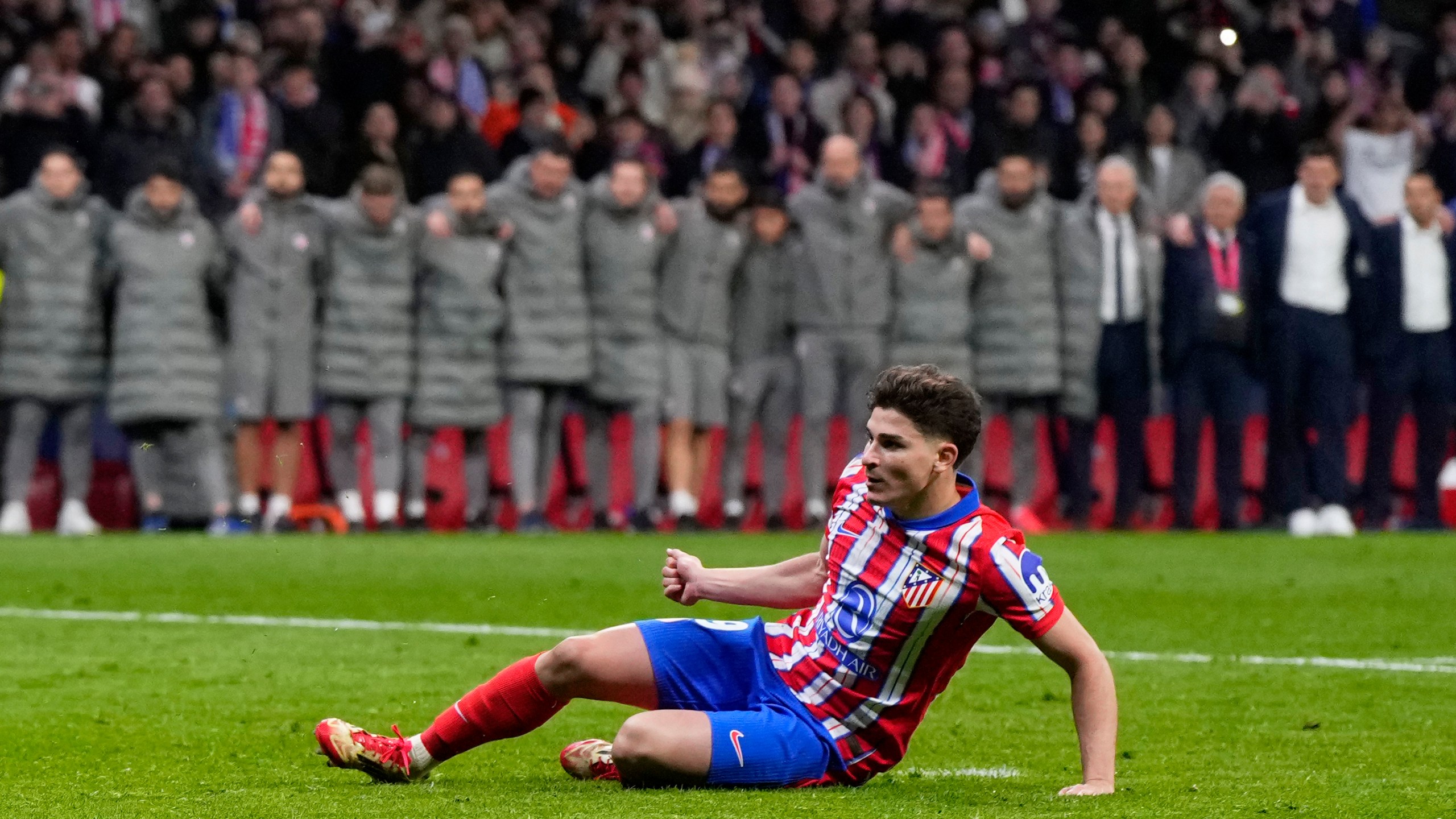 Atletico Madrid's Julian Alvarez falls to the ground after taking a penalty kick during a shootout at the end of the Champions League round of 16, second leg, soccer match between Atletico Madrid and Real Madrid at the Metropolitano stadium in Madrid, Spain, Wednesday, March 12, 2025. (AP Photo/Manu Fernandez)