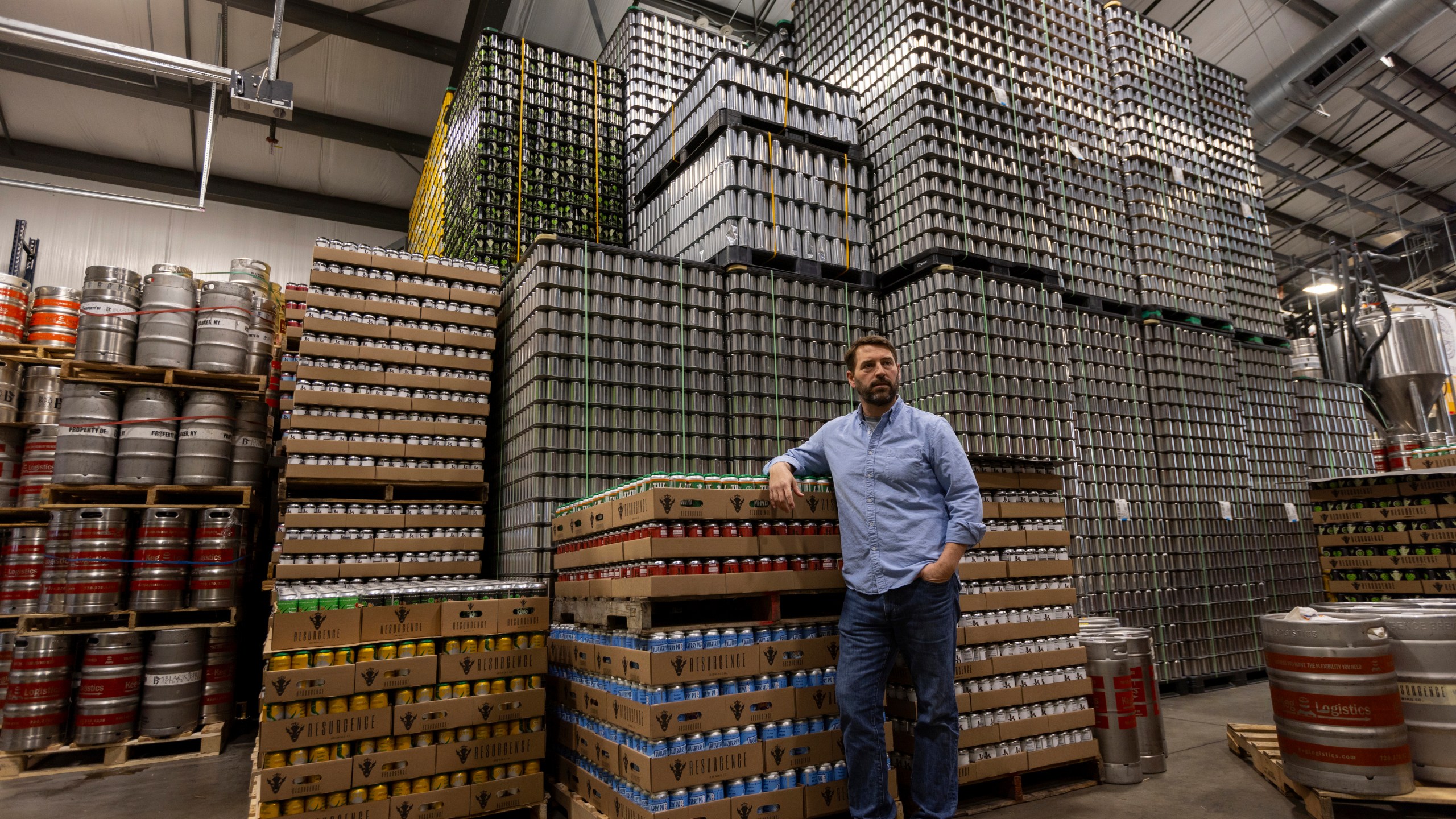 Jeff Ware, president of Resurgence Brewing Company, poses for a portrait near a stockpile of aluminum cans, which are sourced from Canada, Thursday, Feb. 27, 2025, in Buffalo, N.Y. (AP Photo/Lauren Petracca)